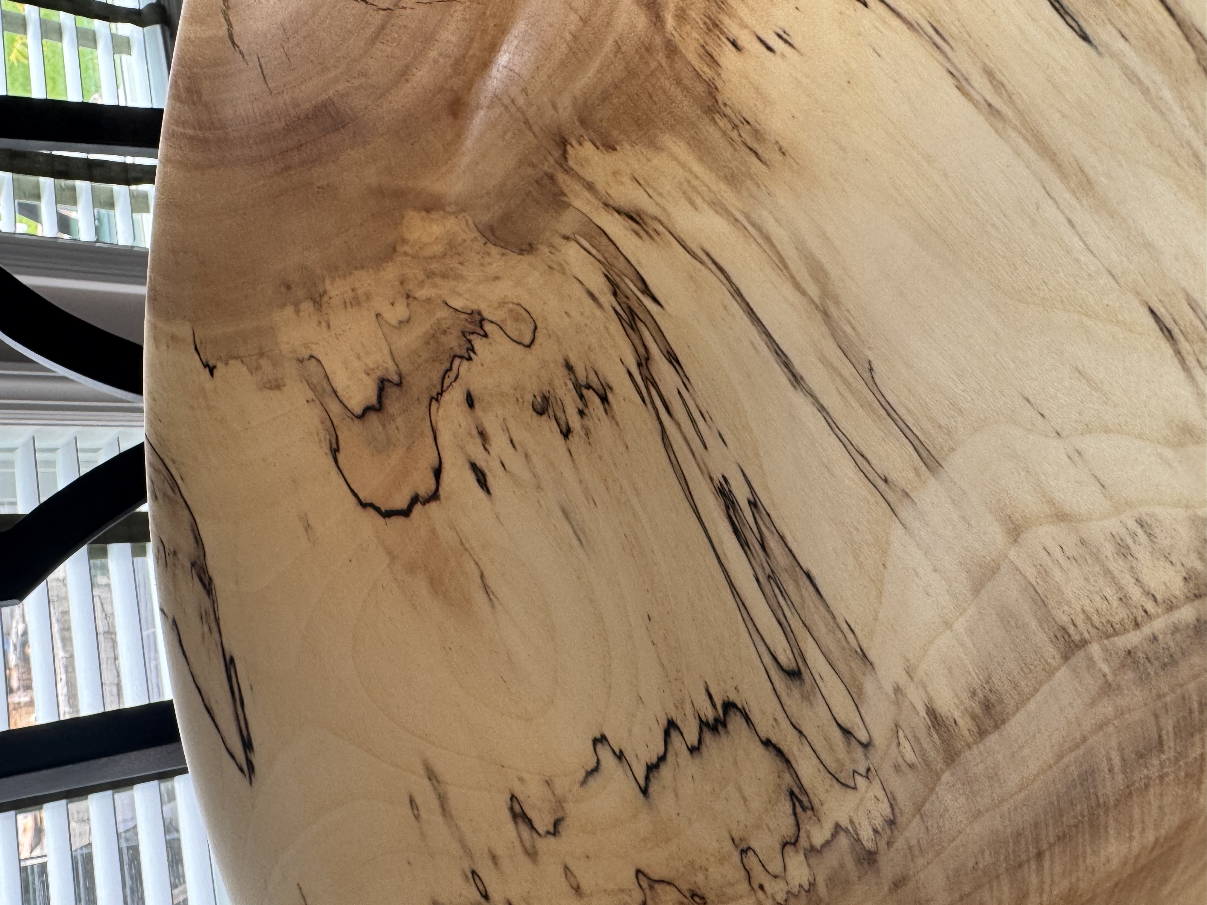 Close-up detail of spalted maple bowl showing dramatic black zone lines and fungal figure in pale wood