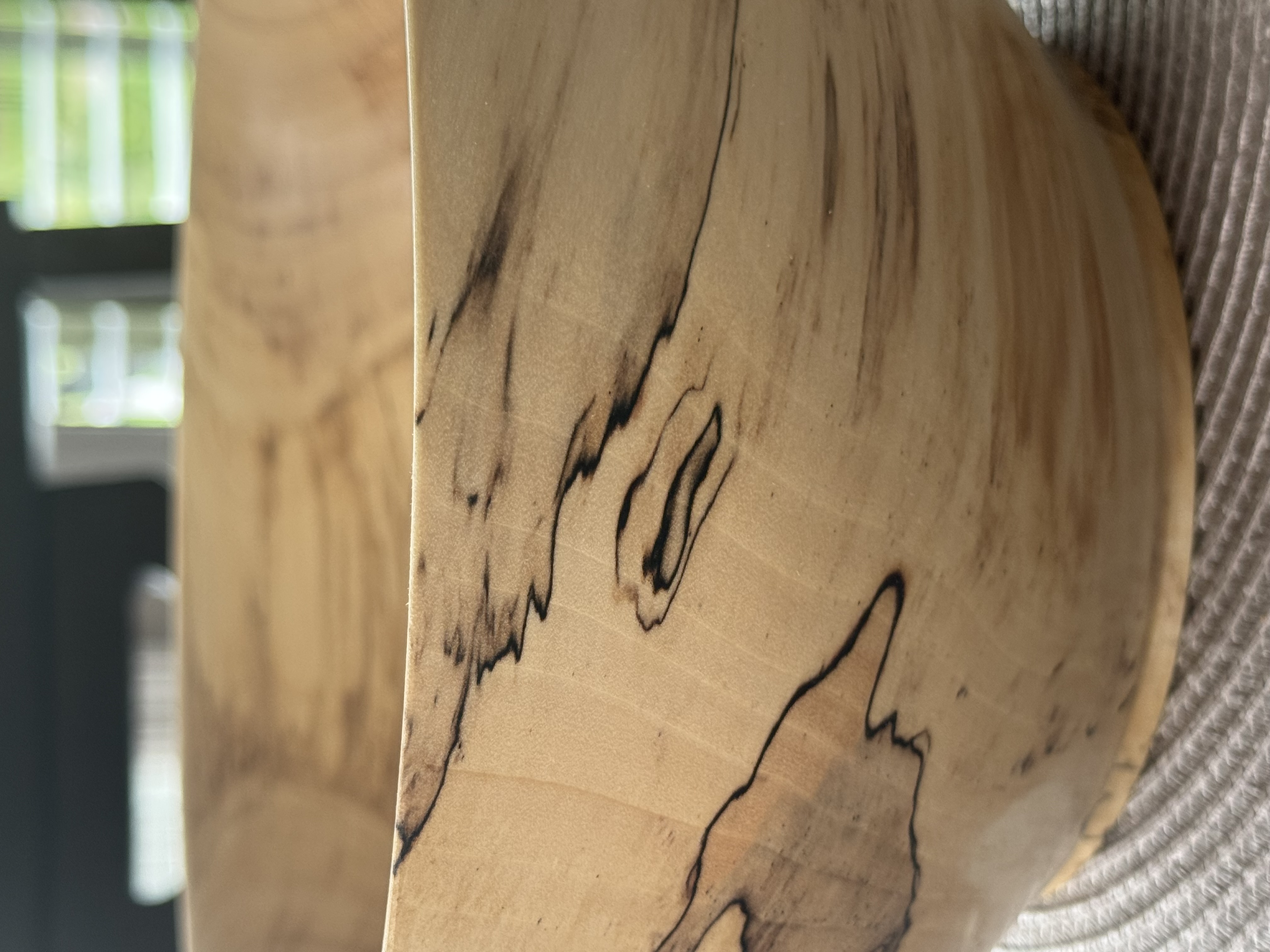 Close-up detail of spalted maple bowl showing dramatic black zone lines and fungal figure in pale wood