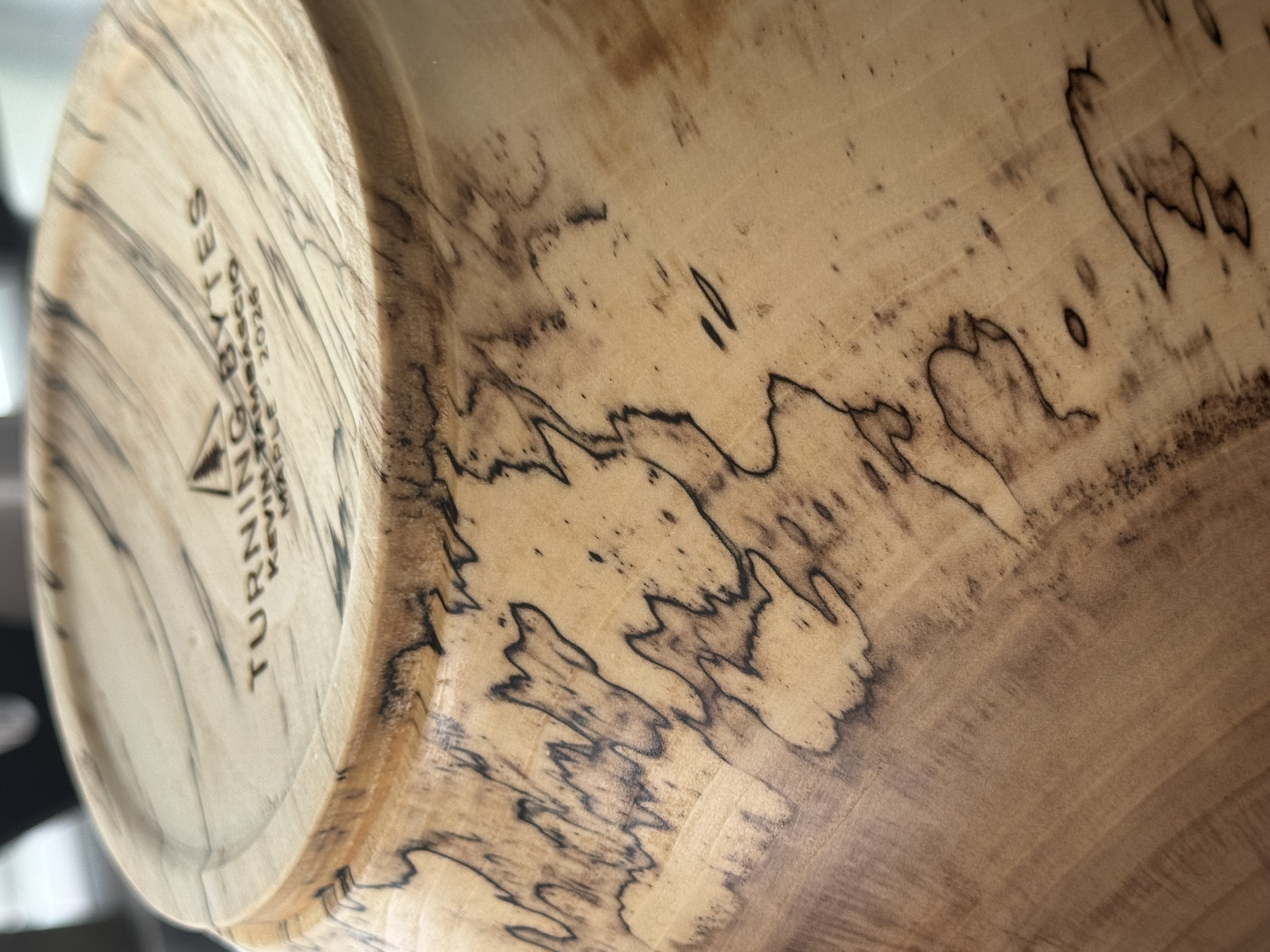 Close-up detail of spalted maple bowl showing dramatic black zone lines and fungal figure in pale wood