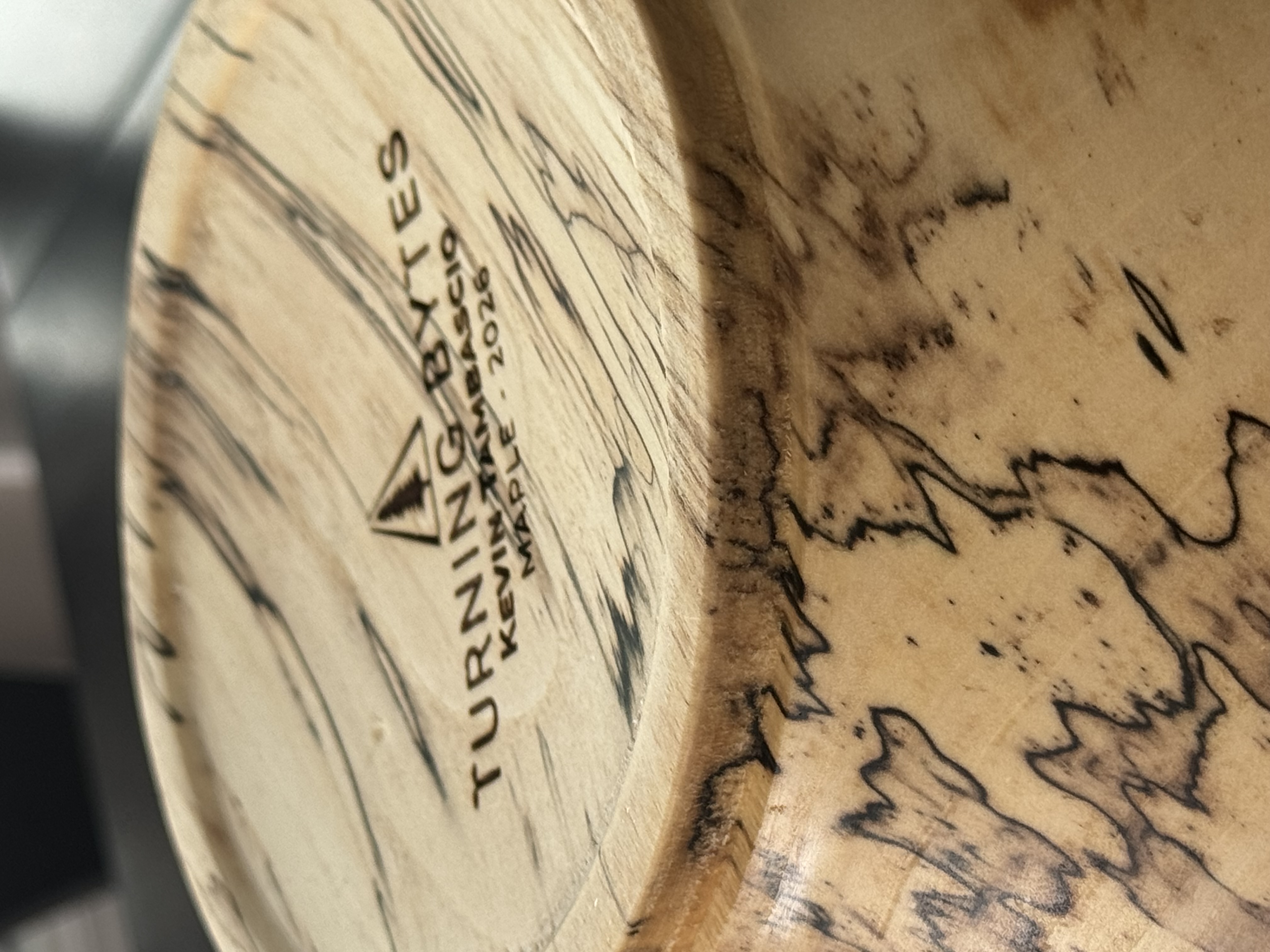 Close-up detail of spalted maple bowl showing dramatic black zone lines and fungal figure in pale wood