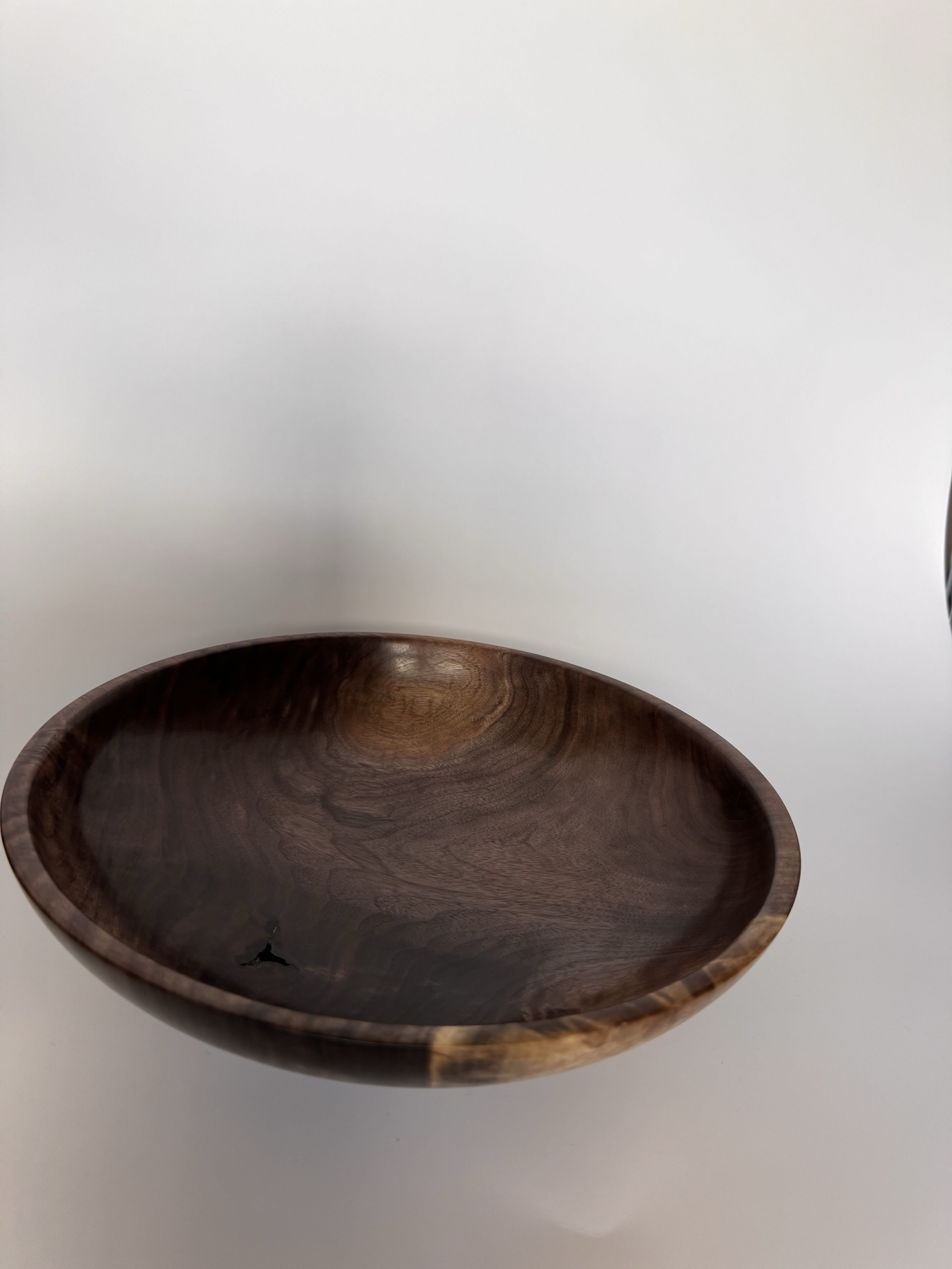 Angled view of black walnut bowl showing the broad rim and warm brown figure