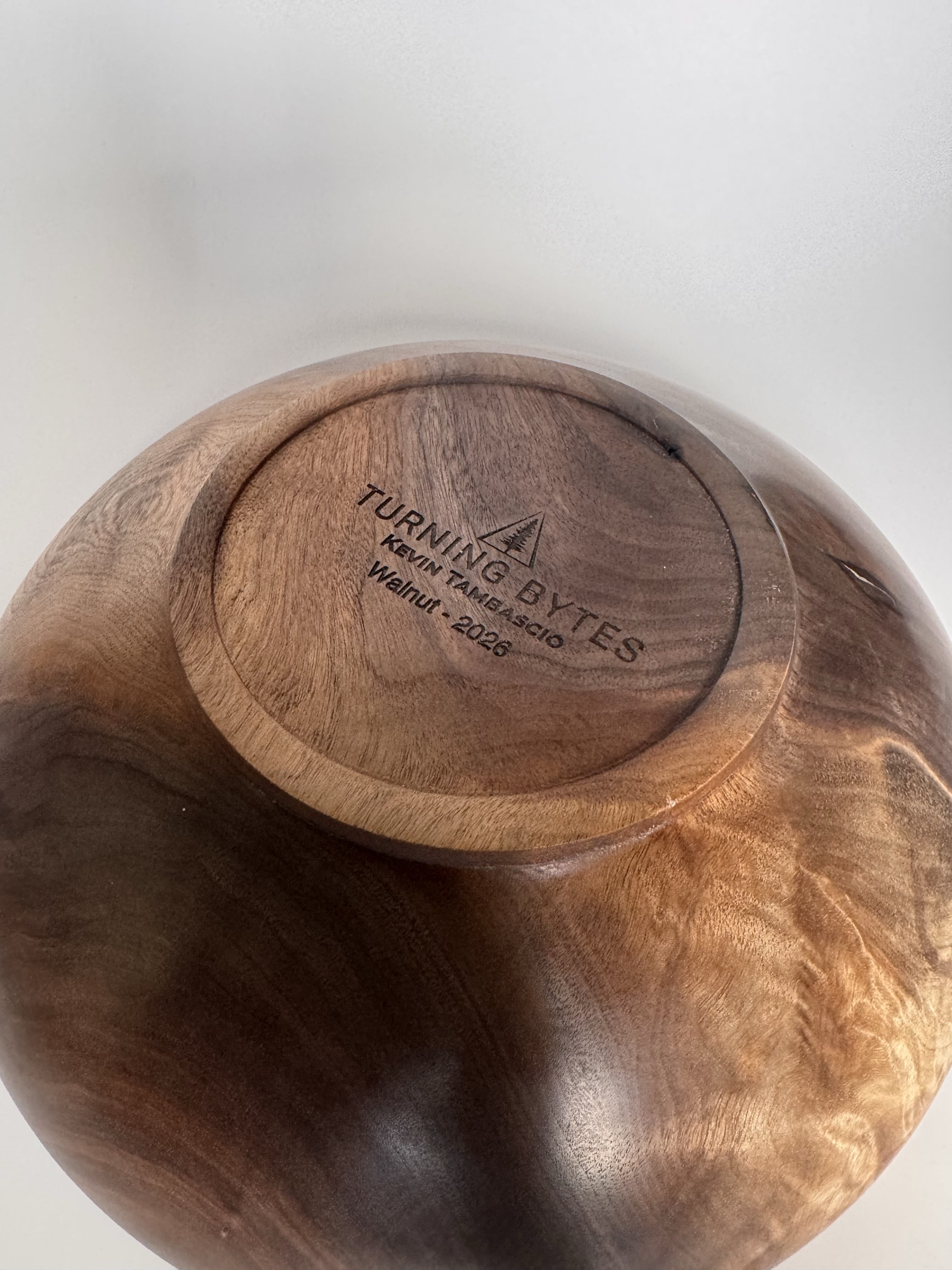 Bottom of black walnut bowl with Turning Bytes maker mark and small raised foot