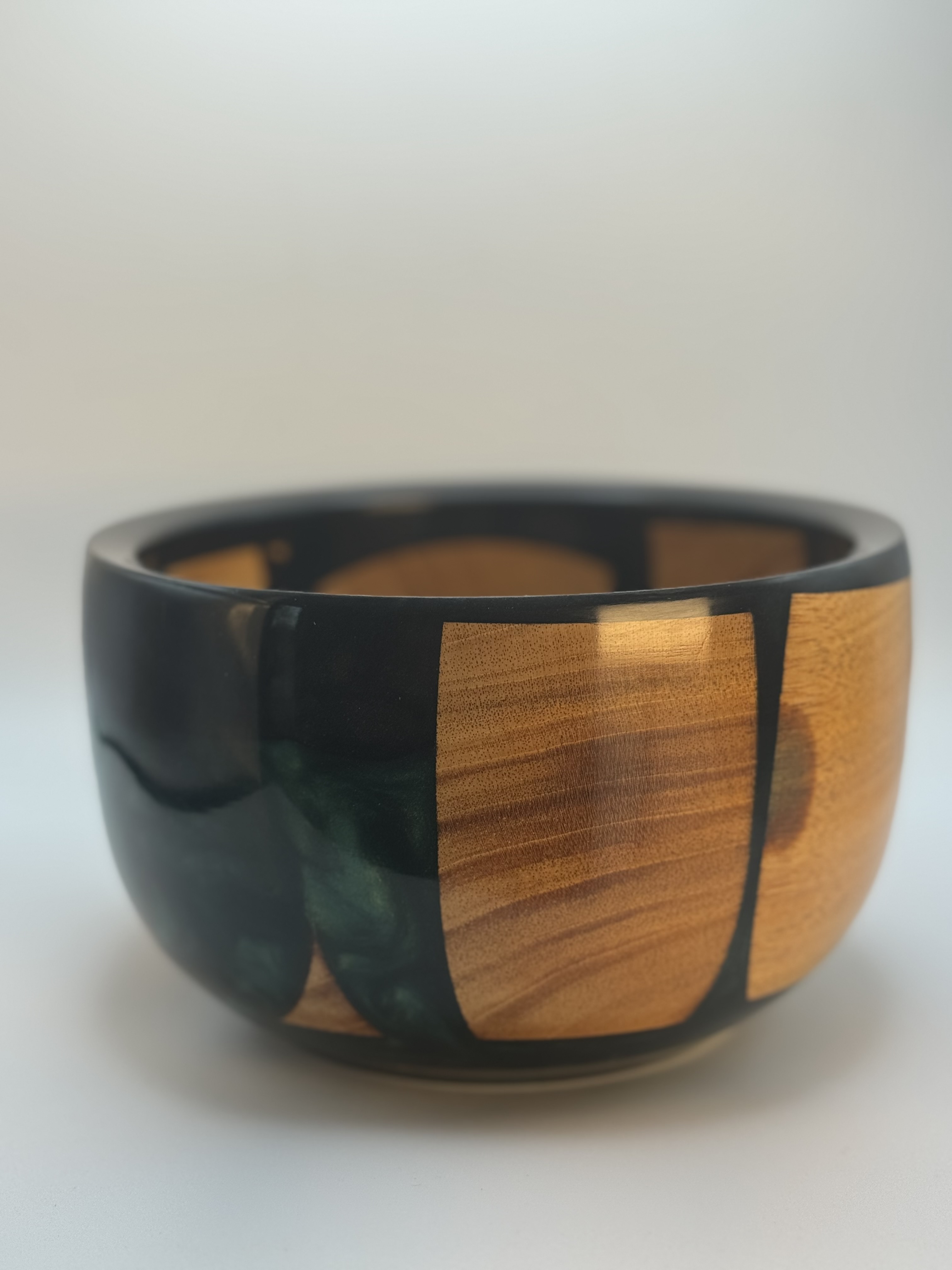 Dark green resin and cherry wood scraps forming a decorative hand-turned bowl